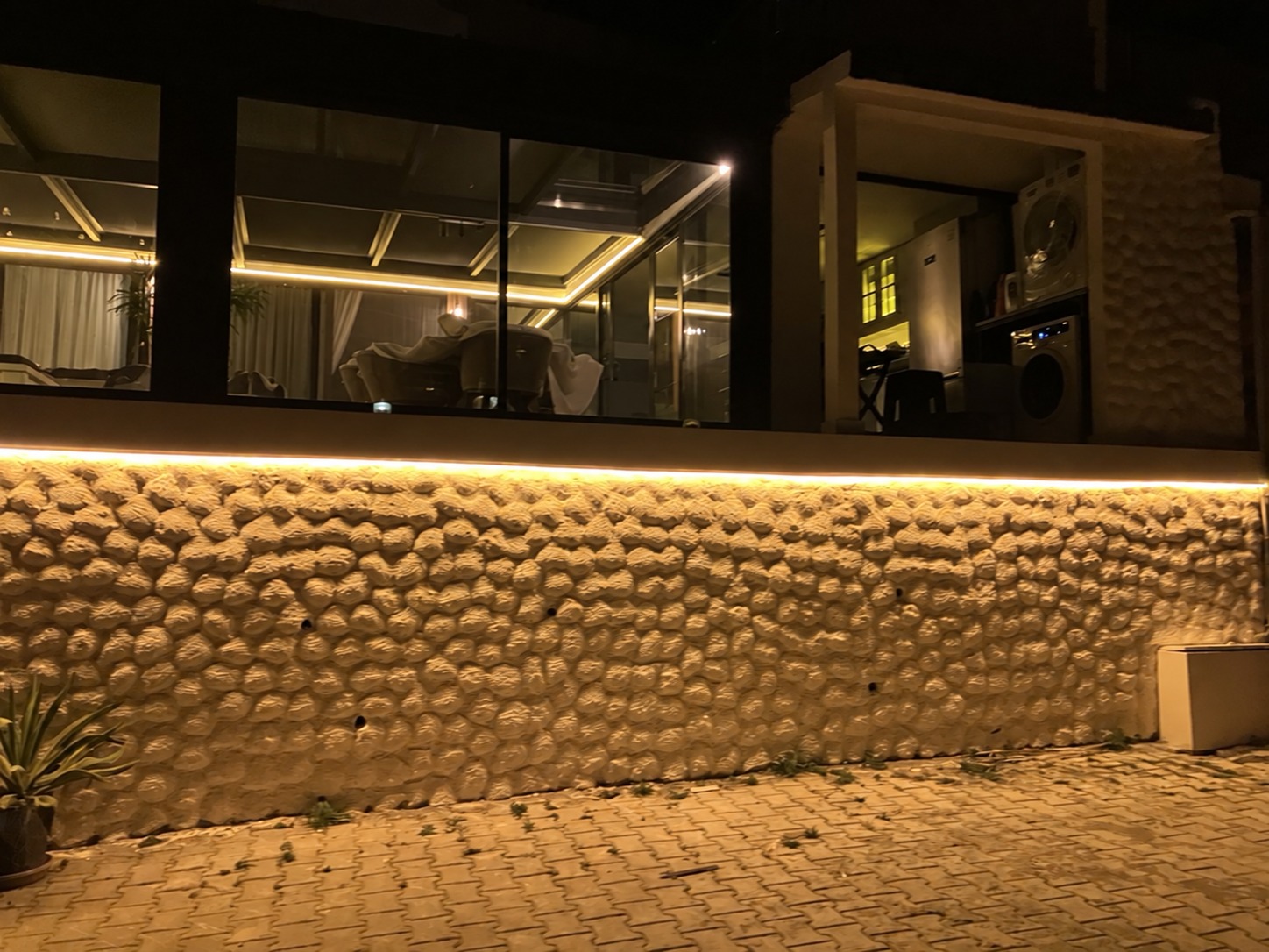 Taş duvar ve cam cephede LED aydınlatmanın yakından görünümü